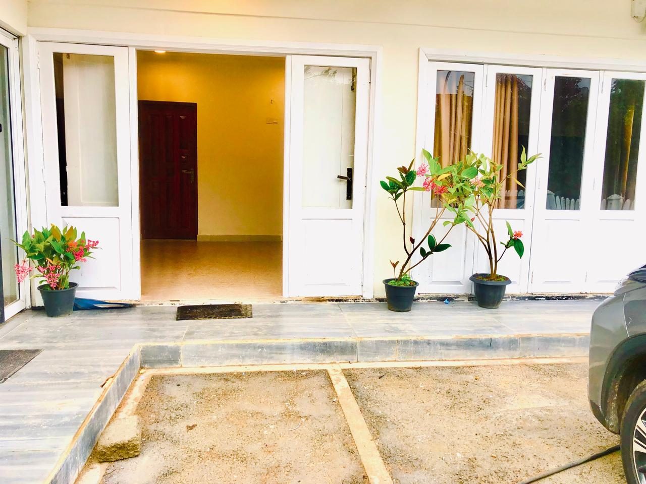 Ground-floor entrance with white doors and potted plants