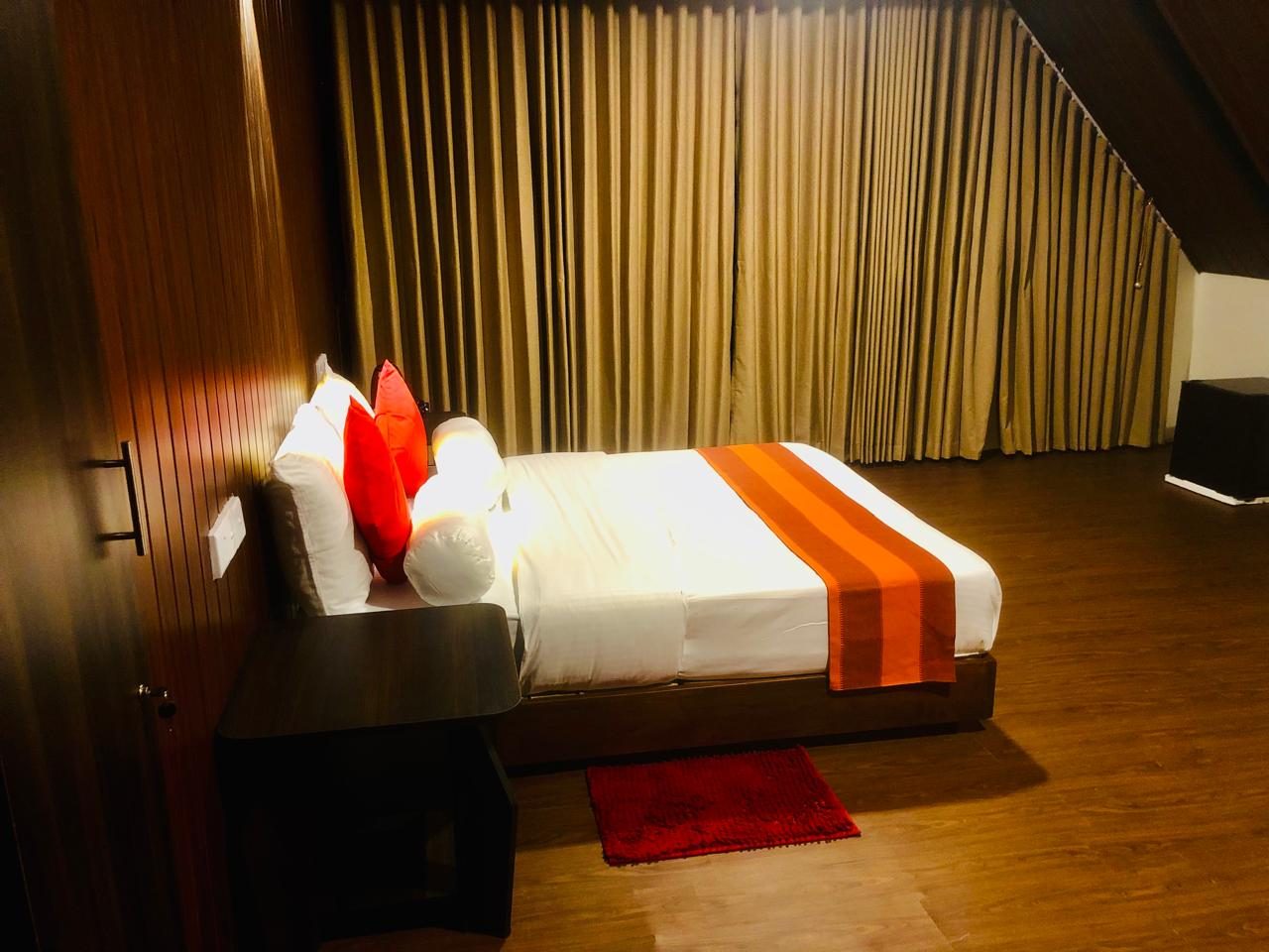 Double Room with Balcony, bed dressed in white and orange under the sloping roof